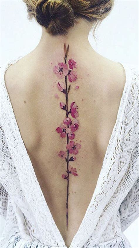 The Back Of A Womans Neck With Pink Flowers On It