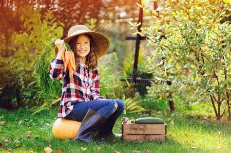 Happy Farmer Child Girl With Autumn Harvest Organic Pumpkins Carrots