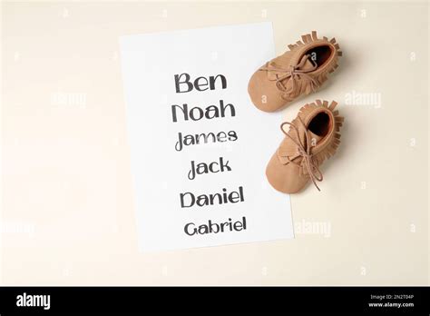 List Of Baby Names And Childs Shoes On Beige Background Flat Lay