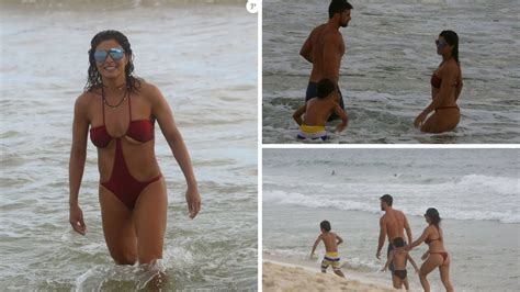 Juliana Paes de maiô cavado curte domingo na praia o marido e os