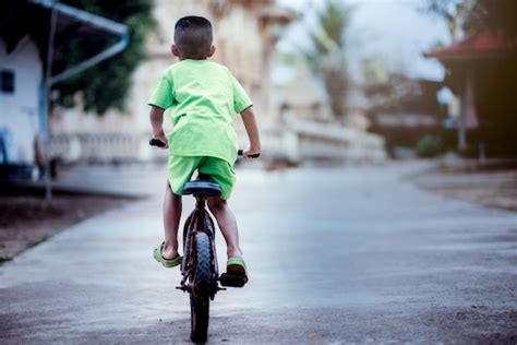 Niño Niño En Una Bicicleta En La Carretera Foto Premium