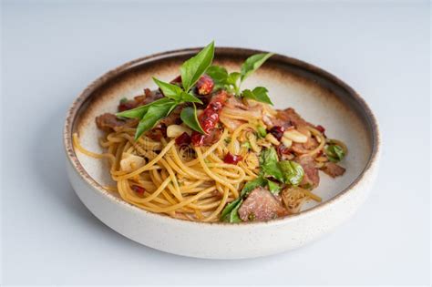 Spicy Thai Basil Pork Pasta On White Dish With White Background