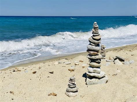 Stacked stones on a beach stock photo. Image of surf - 193551972