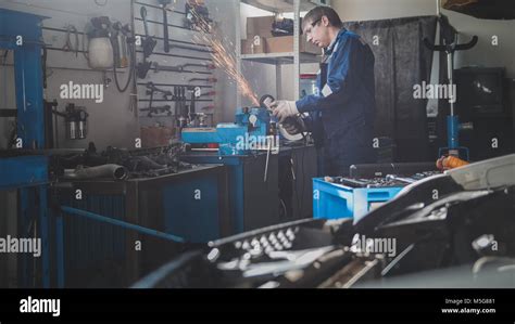 Car Auto Workshop Male Caucasian Mechanic Worker Works With Circular