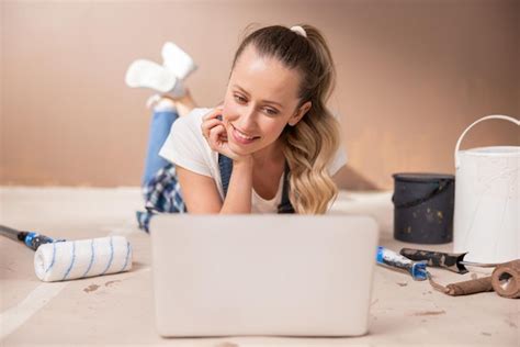 Premium Photo Charismatic Smiling Blonde Lying On The Floor In Front Of The Laptop Near Her