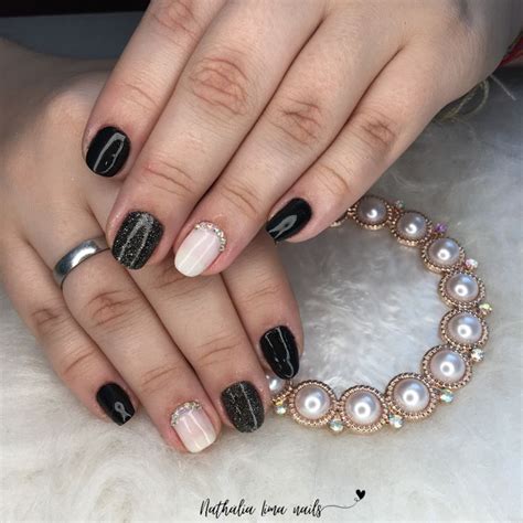 A Woman S Hands With Black And White Nail Polishes On Her Nails