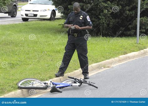 A Police Officer Investigates A Bicyclist Hit By A Hit And Run Driver