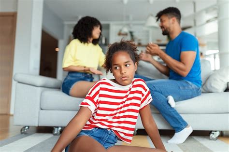 Premium Photo | Upset kid daughter feels sad of parents fighting quarreling looking at camera ...