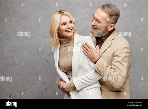 Elegant Mature Man And Woman In Debonair Attire Standing Together