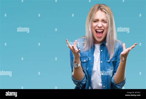 Junge blonde Frau über isolierte Hintergrund verrückt und wütenden Schreien und Kreischen mit
