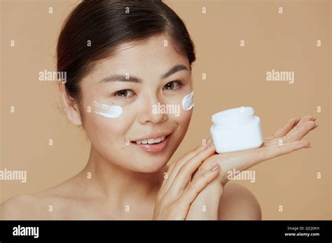 Portrait Of Modern Asian Female With Facial Cream Jar And Facial Cream