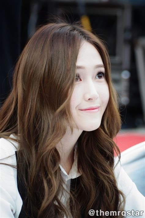 A Woman With Long Brown Hair Sitting In Front Of A Car