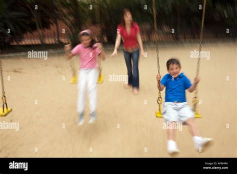 Mother and children in playground Stock Photo - Alamy