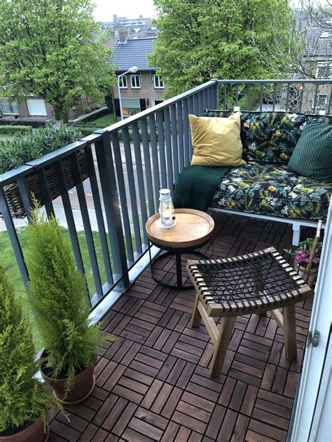 A Balcony With Two Chairs And A Table On The Floor Next To Potted Plants