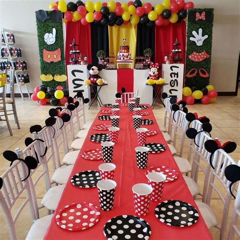 A Mickey Mouse Themed Birthday Party With Red Table Cloths And Black