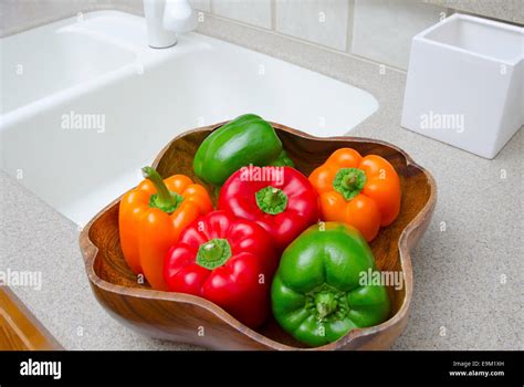 Bowl Of Peppers Red Green And Orange Bell Peppers In A Wood Bowl In A Modern Kitchen Stock