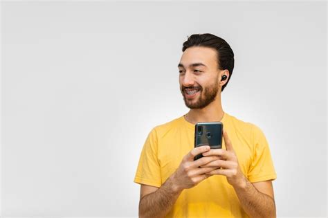 Gay queer joven latino con auriculares inalámbricos mirando hacia otro