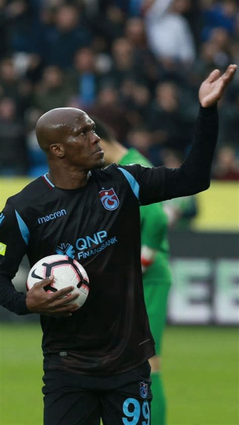 A Man Holding A Soccer Ball On Top Of A Field