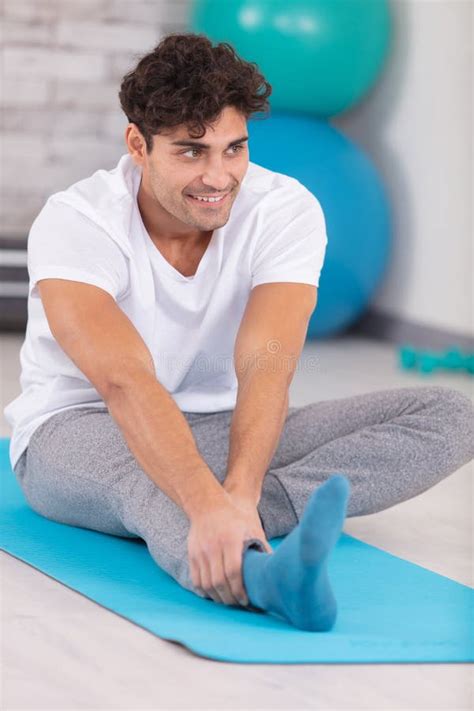 Man Ing Forward Stretch On Yoga Mat Stock Image Image Of Serene Indoors 309076989