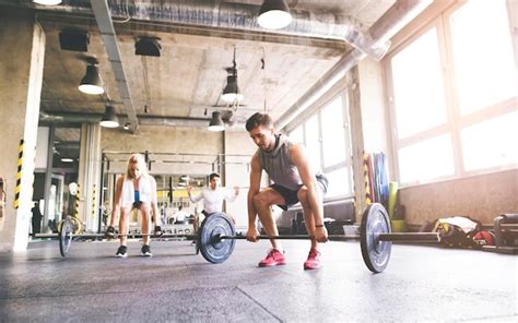 Premium Photo | Group of young fit people weightlifting in gym