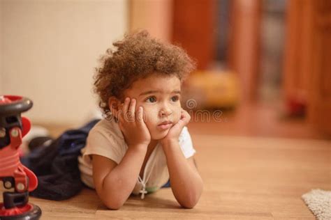 Fille Mignonne De Petit Afro américain S étendant Sur Le Plancher Avec