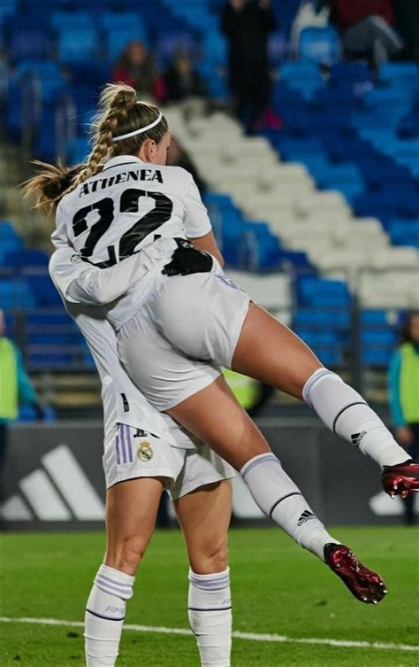 Two Women Are Playing Soccer On The Field