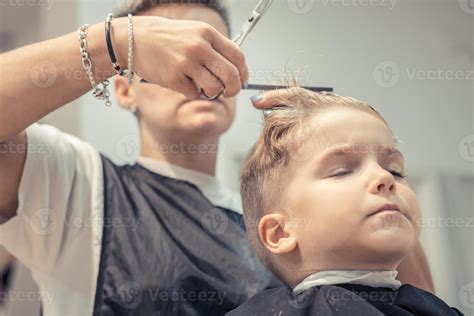 Small boy during haircut at hair salon. 12663406 Stock Photo at Vecteezy