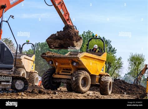 Excavator Loads Earth Into Tipper Truck On Construction Site Stock