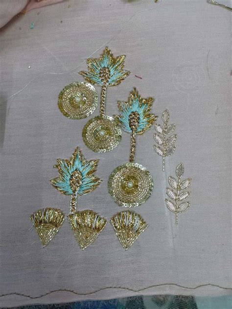 Some Gold And Blue Brooches Are Sitting On A White Piece Of Cloth That