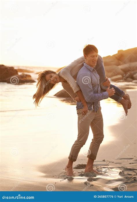 Partners At Play A Happy Young Couple Having Fun On The Beach At