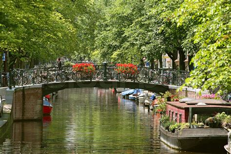 Vis på lille bro med blomster og cykler over kanalen Amstel River i