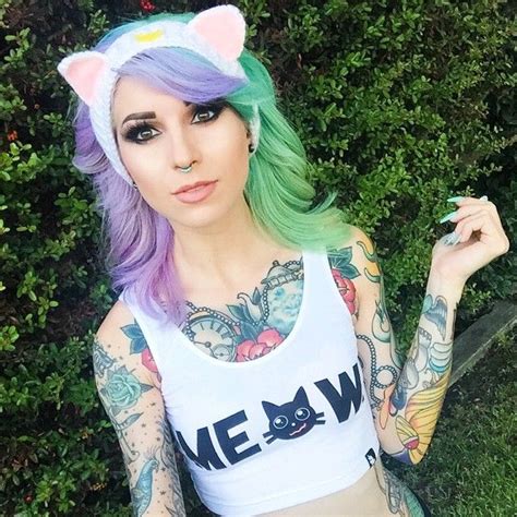 A Woman With Green Hair Wearing A White Tank Top And Cat Ears On Her Head