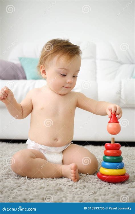 Cute Little Kid In Nappy Sits On Carpet And Plays Stock Photo Image
