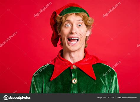 Photo Of Handsome Guy Look Camera Open Mouth Excited Wear Santa Elf Green Costume Headwear Red