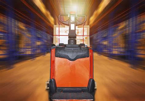 Electric Forklift Pallet Jack With Package Boxes In Blurred Warehouse