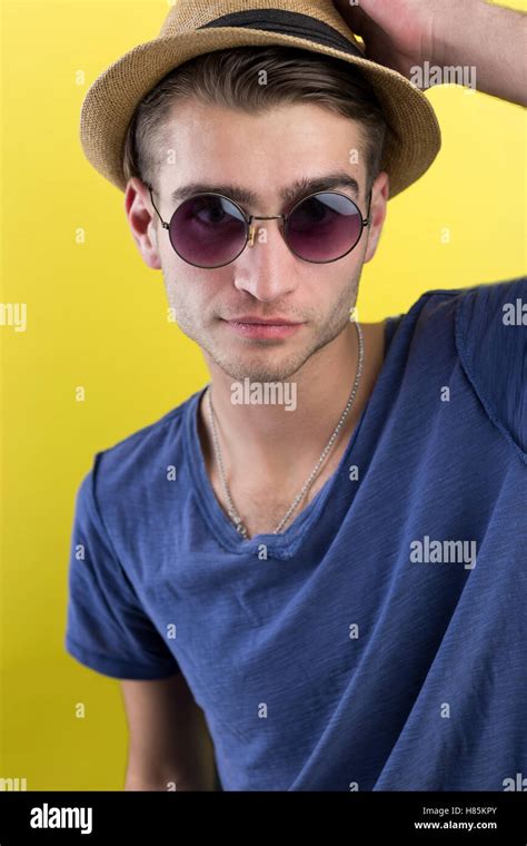 Cheerful Young Man In Hat And Sunglasses Over Yellow Background Stock