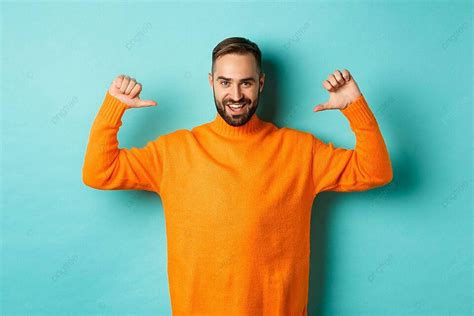 Confident Man In Orange Sweater Pointing At Himself Photo Background