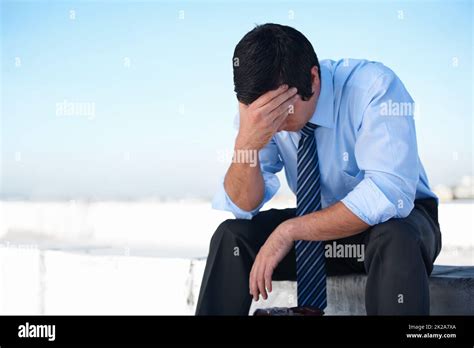 Fighting Deppression An Upset Corporate Man Sitting On The Rooftop Of