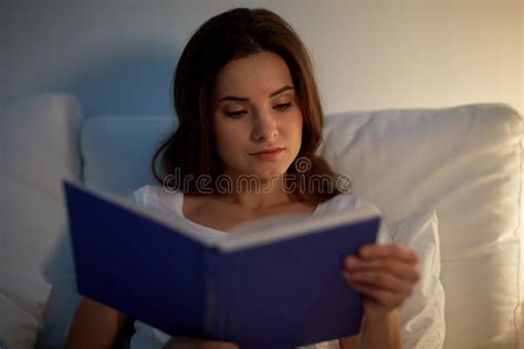 Livro De Leitura Da Jovem Mulher Na Cama Na Casa Da Noite Foto De Stock