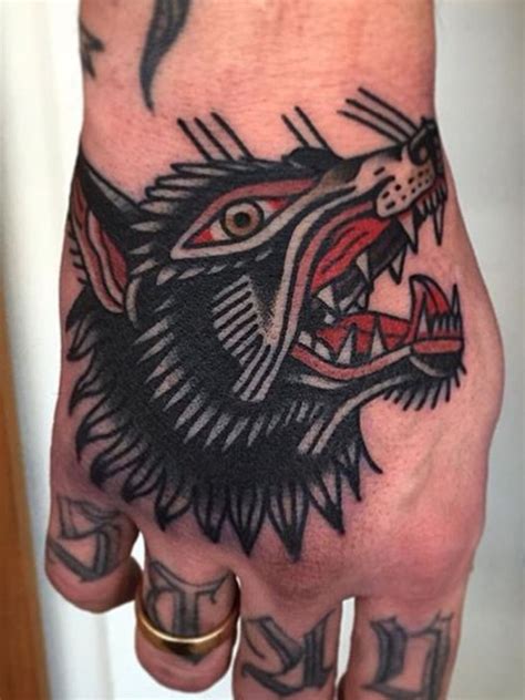 A Man S Hand With A Wolf Tattoo On It And An Arrow In The Middle