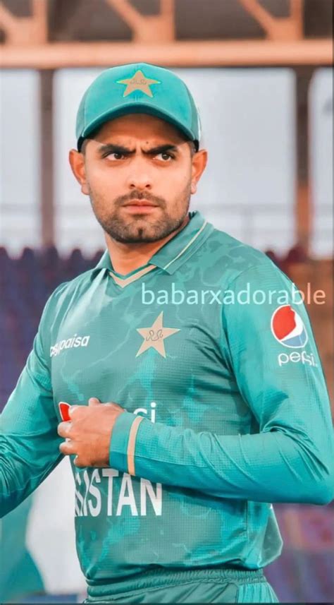 A Man In Green Uniform Holding A Tennis Racquet