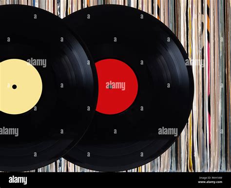 Two Black Vinyl Records With Color Labels In Front Of Pile Of Many