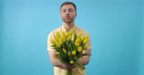 Man Holding Bouquet Of Yellow Flowers And Kissing On Blue Background People Stock Footage Ft