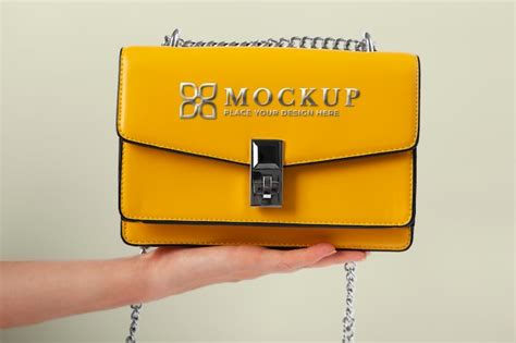 Premium Psd Hand Holding Yellow Handbag With Golden Logo