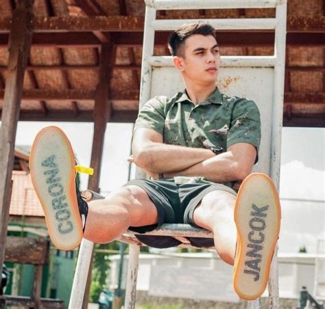 A Man Sitting On Top Of A White Ladder