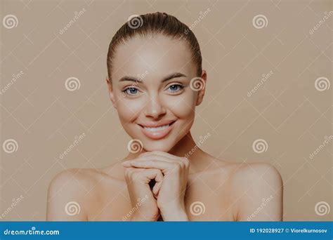 Close Up Shot Of Adult Woman With Fresh Daily Makeup Smiles Toothily And Keeps Hands Under Chin