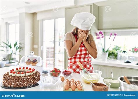 Beautiful Young Brunette Pastry Chef Woman Cooking Pastries At The Kitchen With Sad Expression