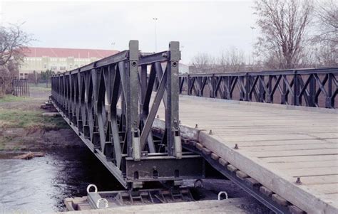 An Old Bridge Over A River With Birds On It