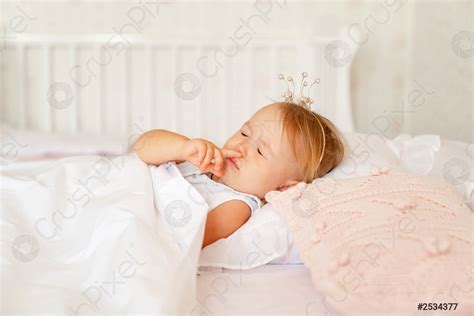 Little girl sleeping in the bed in the bedroom with - stock photo | Crushpixel