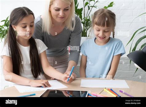 mère et deux filles qui font leurs devoirs à écrire et à lire accueil